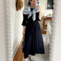 Carly Riordan taking a mirror selfie wearing a navy shirtdress and silk scarf.